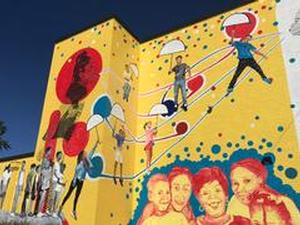 Mural going up in North Danville showing kids floating to a better future